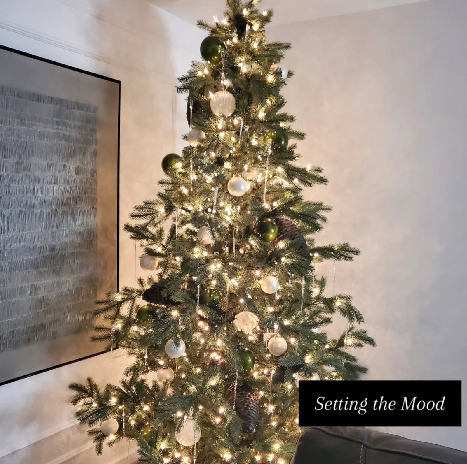 Warmly lit Christmas tree with white and green ornaments