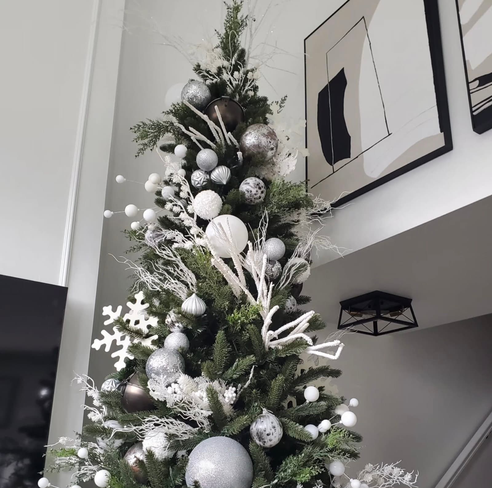 Close-up of white and silver ornaments and frosted branches on a Christmas tree