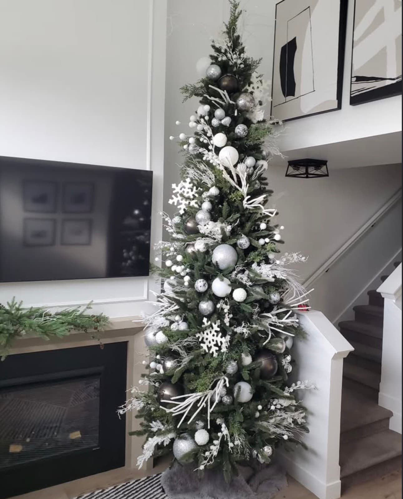 Slim Christmas tree styled in white and silver with snowflakes and frosted branches